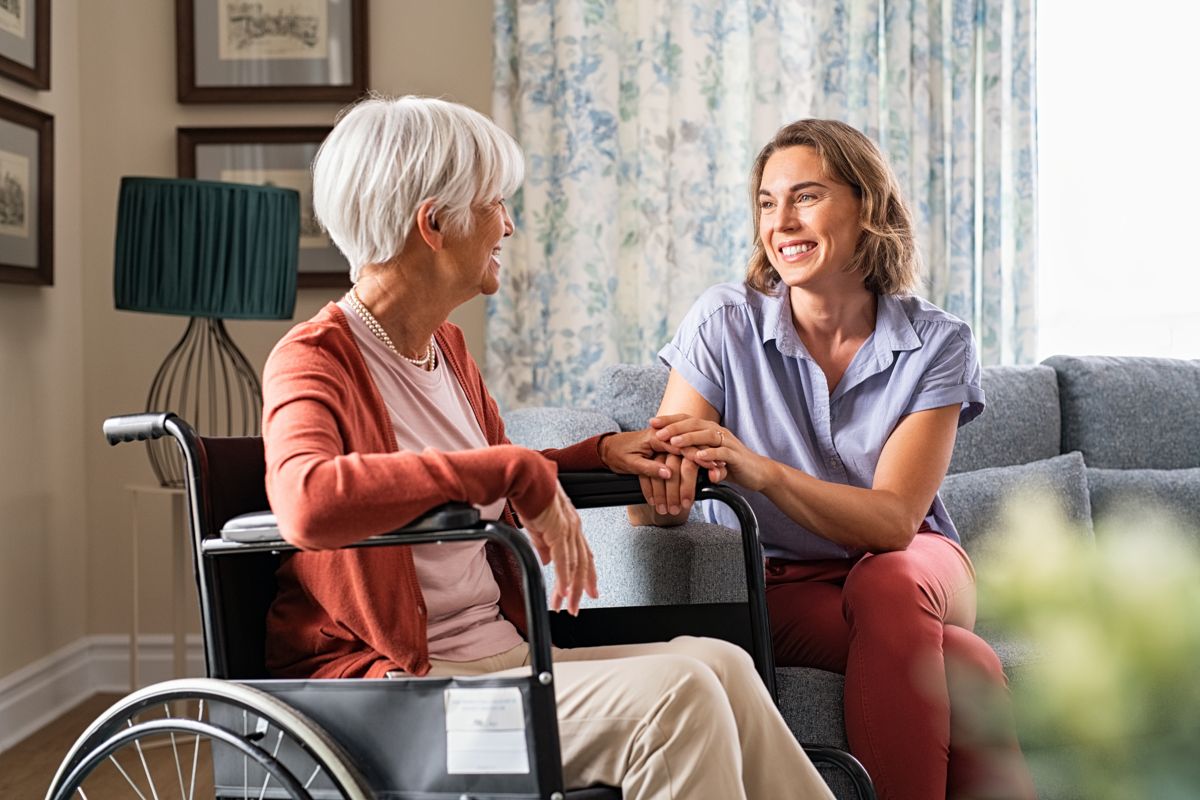Mature,Woman,Comforting,Senior,Mom,Sitting,On,Wheelchair,At,Nursing